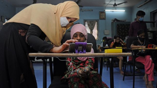 Niña aprendiendo a través de un teléfono en India.